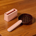 Pink and brown pet litter scoop with holder on wooden surface